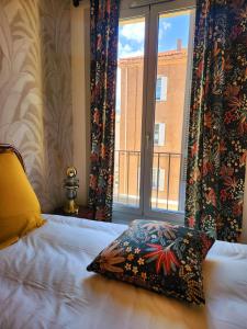 a bedroom with a bed with a pillow and a window at Superbe Appartement - Centre Calvi - Parking privé in Calvi