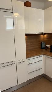 una cucina con mobili bianchi e un frigorifero di two double bedrooms in center a Vienna
