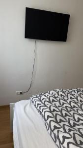 un letto con una televisione a parete di two double bedrooms in center a Vienna
