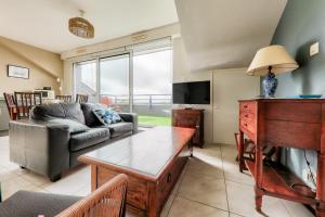 a living room with a couch and a table at Appartement pour 4 avec grand balcon in Sarzeau