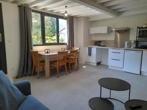 a kitchen and dining room with a table and chairs at Le petit résineux in La Chambre