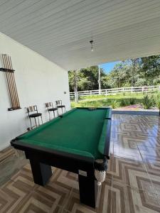 einen Billardtisch in einem Zimmer mit 2 Stühlen in der Unterkunft Pousada dos Passarinhos in Água Boa