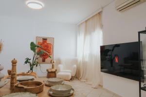 a living room with a table with dishes on it at The Boho Blue in Igoumenitsa