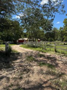 ein Feldweg mit einem Zaun und einer Scheune in der Unterkunft Pousada dos Passarinhos in Água Boa + 20 Fotos