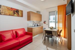 a living room with a red couch and a table at Residence Marzia in Rimini