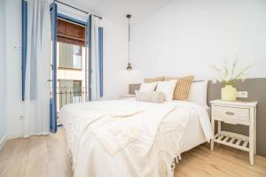 a white bedroom with a bed and a window at Milenial Immo ADC1-1 Apartment 200m Dali Museum in Figueres