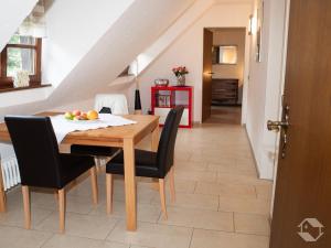 a dining room with a wooden table and black chairs at Wein- und Vesperstube in Vogtsburg +30 photos