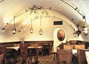a dining room with tables and chairs and lights at Wein- und Vesperstube in Vogtsburg