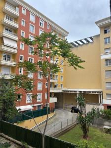 an apartment building with a tree in front of it at Studio Calif, face tram proche Mer in Nice