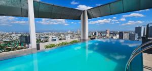 a swimming pool on the roof of a building with a view at Laidback Cavern at Vinia Residences in Manila
