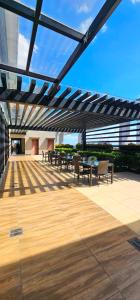 a patio with tables and chairs under a pergola at Laidback Cavern at Vinia Residences in Manila