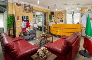 a lobby with two leather couches and a yellow wall at Residence Marzia in Rimini