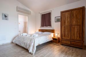 a bedroom with a bed and a large wooden cabinet at Albergo Pietriccio Rosso in Manciano +108 photos
