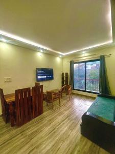 Una sala de estar con una mesa y una gran ventana. en ZenRoofs- Cloud Haven 5BHK Villa, en Mussoorie