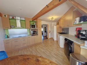 a large kitchen with wooden cabinets and a wooden table at Ty Nomad in Plougonvelin