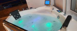 a bath tub filled with blue water in a bathroom at Eye Luxury Penthouse & apartment in Sarandë +110 photos