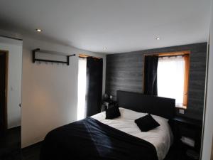 a bedroom with a black and white bed and a window at Spacieux appartement 5 pièces près des pistes, jusqu'à 12 personnes, parking et balcons - FR-1-411-851 in Landry