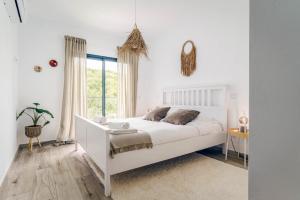 アルジェズールにあるSeabreeze Apartment - Your Beachside Getawayのベッドと窓のある白い寝室