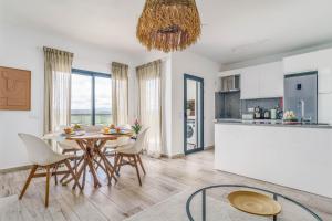 アルジェズールにあるSeabreeze Apartment - Your Beachside Getawayのテーブルと椅子のあるキッチンとダイニングルーム