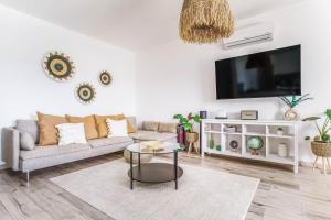 アルジェズールにあるSeabreeze Apartment - Your Beachside Getawayのソファとテレビのあるリビングルーム