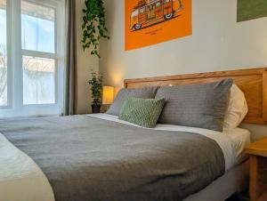 a bedroom with a large bed with an orange picture on the wall at Studio 8 - 2 min du Bord de l'eau Foyer & Barbecue in Sainte-Anne-de-Beaupré