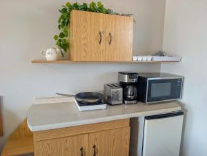 a kitchen with a counter with a microwave and a coffee maker at Studio 8 - 2 min du Bord de l'eau Foyer & Barbecue in Sainte-Anne-de-Beaupré +28 photos
