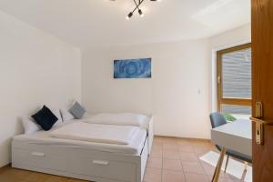 下乌尔丁根Seeside的一间带床和书桌的白色卧室