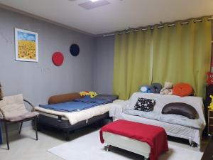 Rest place with beautiful flowers في دايغو: غرفة بسريرين واريكة وكرسي