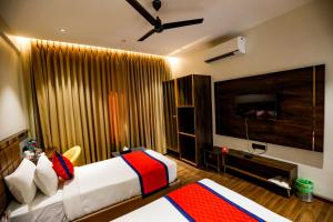 a hotel room with two beds and a flat screen tv at Spree Manor Hotel in Aurangabad +46 photos