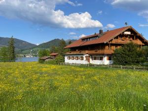 a wooden house in a field of flowers at Landhaus Christl am See in Bad Wiessee