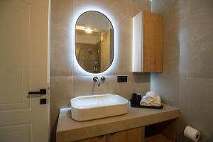 a bathroom with a sink and a mirror at Likehome Apartments in Orestiada +50 photos