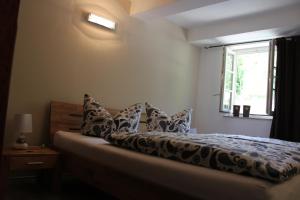 ein Schlafzimmer mit einem Bett mit Kissen und einem Fenster in der Unterkunft Ferienwohnungen Im Alten Handelshof in Quedlinburg