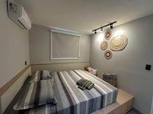 a bedroom with a large bed with a blanket at Apartamento moderno com 2 quartos e cama queen-size in Caruaru