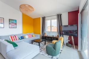 a living room with a couch and a tv at Bel appartement avec terrasse vue rhune, parking et proche des plages de Bidart in Bidart +4 photos