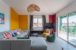 a living room with a couch and a tv at Bel appartement avec terrasse vue rhune, parking et proche des plages de Bidart in Bidart