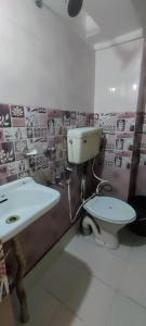 un baño con inodoro y lavabo en Om Sona Guest House, en Digha