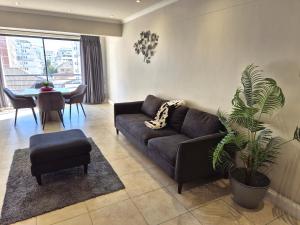 a living room with a couch and a table at Prime location in The Firmont, Sea Point in Cape Town