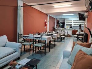 a dining room with tables and chairs and a waitress at Hostal Alto Ayre Salta in Salta