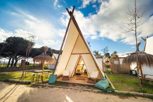 una pequeña casa triangular con techo de paja en Kampaoh Tarifa, en Tarifa