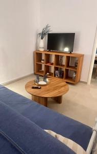 a living room with a tv and a wooden coffee table at Thalassea house1 Lipsi in Lipsoi