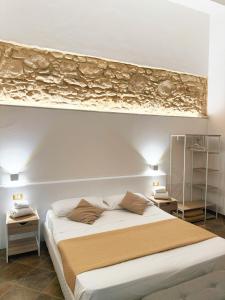 a bedroom with a large bed with a painting on the wall at Balcone Mediterraneo - Donnalucata & Marina di Ragusa in Ragusa