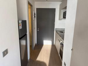 a hallway leading to a kitchen with a refrigerator at Apartamento Centro Maipú in Concepción