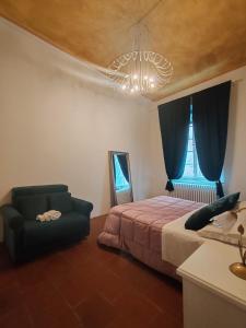 - une chambre avec un lit, une chaise et un lustre dans l'établissement Corte Pini Deluxe Apartment in historic center of Lucca, à Lucques 14 autres photos
