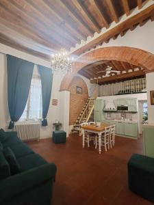 un salon avec une table et une cuisine dans l'établissement Corte Pini Deluxe Apartment in historic center of Lucca, à Lucques