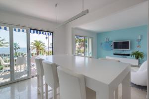 Un comedor blanco con una mesa y sillas blancas. en 3P ST Jean, en Saint-Jean-Cap-Ferrat