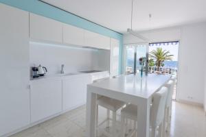a white kitchen with a white table and chairs at 3P ST Jean in Saint-Jean-Cap-Ferrat