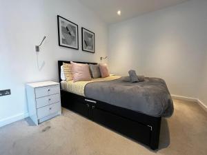 a bedroom with a bed and a white night stand at Grosvenor Rd - 2-Bedrooms - Sleeps 5 - Parking in Saint Albans +8 photos