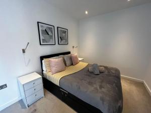 a bedroom with a bed with a nightstand and a bed sidx sidx sidx sidx at Grosvenor Rd - 2-Bedrooms - Sleeps 5 - Parking in Saint Albans