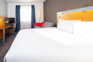 una camera d'albergo con un letto grande e una scrivania di Holiday Inn Express Bedford by IHG a Bedford