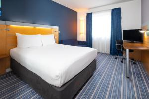 una camera d'albergo con un letto grande e una scrivania di Holiday Inn Express Bedford by IHG a Bedford Altre 24 foto